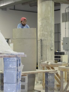 Apprentice hand building the very tall ceramic dongos