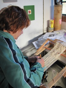 Kissiah Carlson weaving an image of a young boy on a loom brought by a Brazilian weaver from the previous course